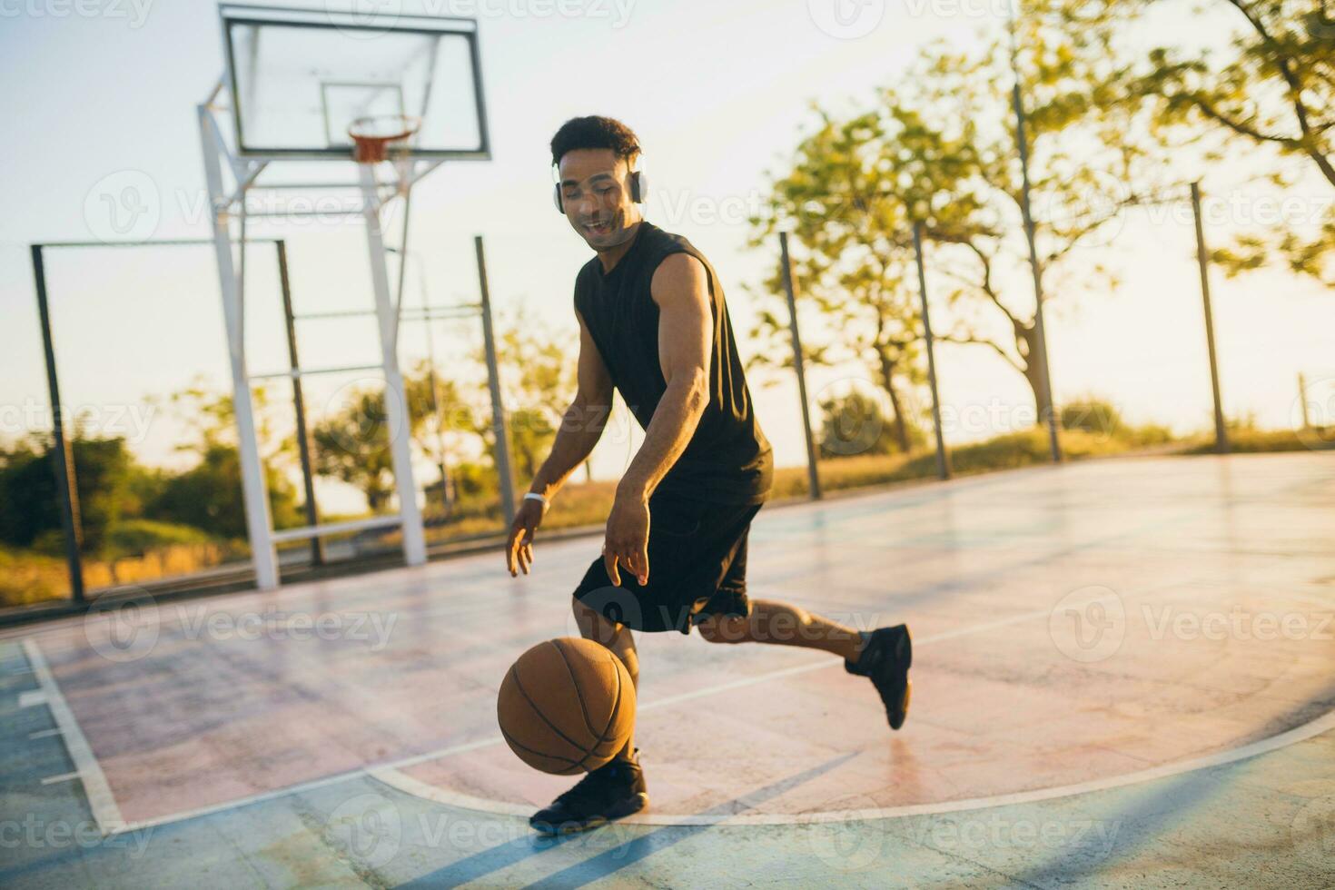 black man doing sports, playing basketball on sunrise, active lifestyle, sunny summer morning photo