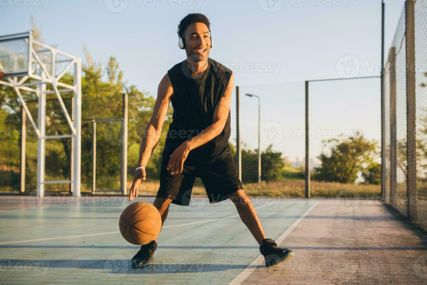 black man doing sports, playing basketball on sunrise, active lifestyle, sunny summer morning photo