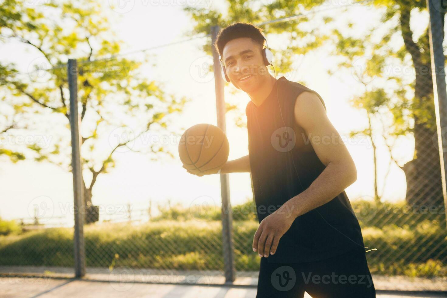 black man doing sports, playing basketball on sunrise, active lifestyle, sunny summer morning photo