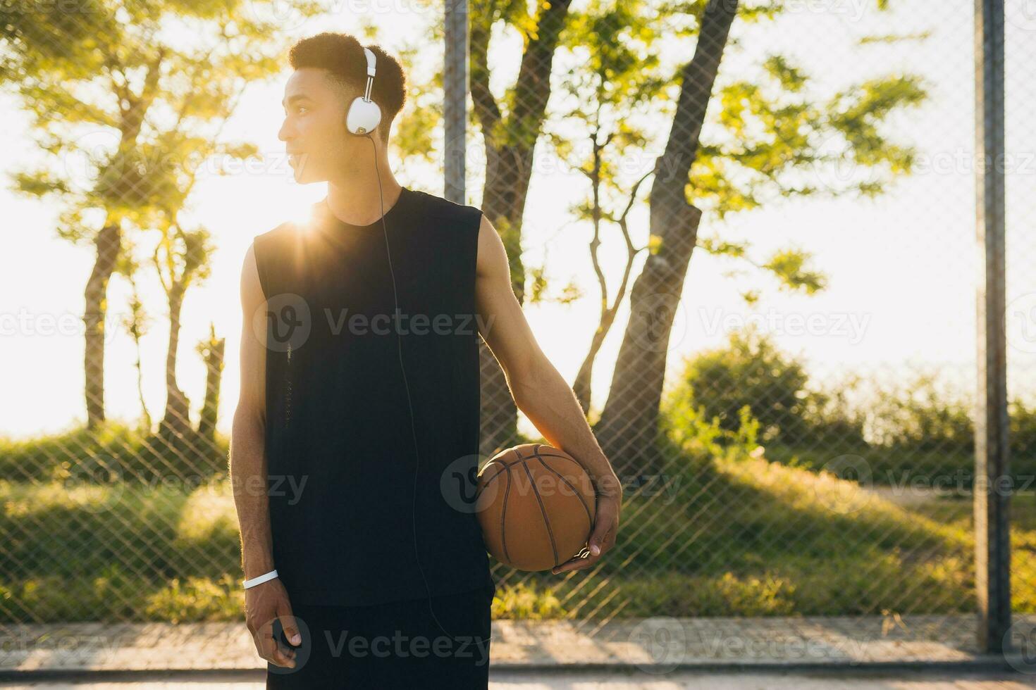 black man doing sports, playing basketball on sunrise, active lifestyle, sunny summer morning photo