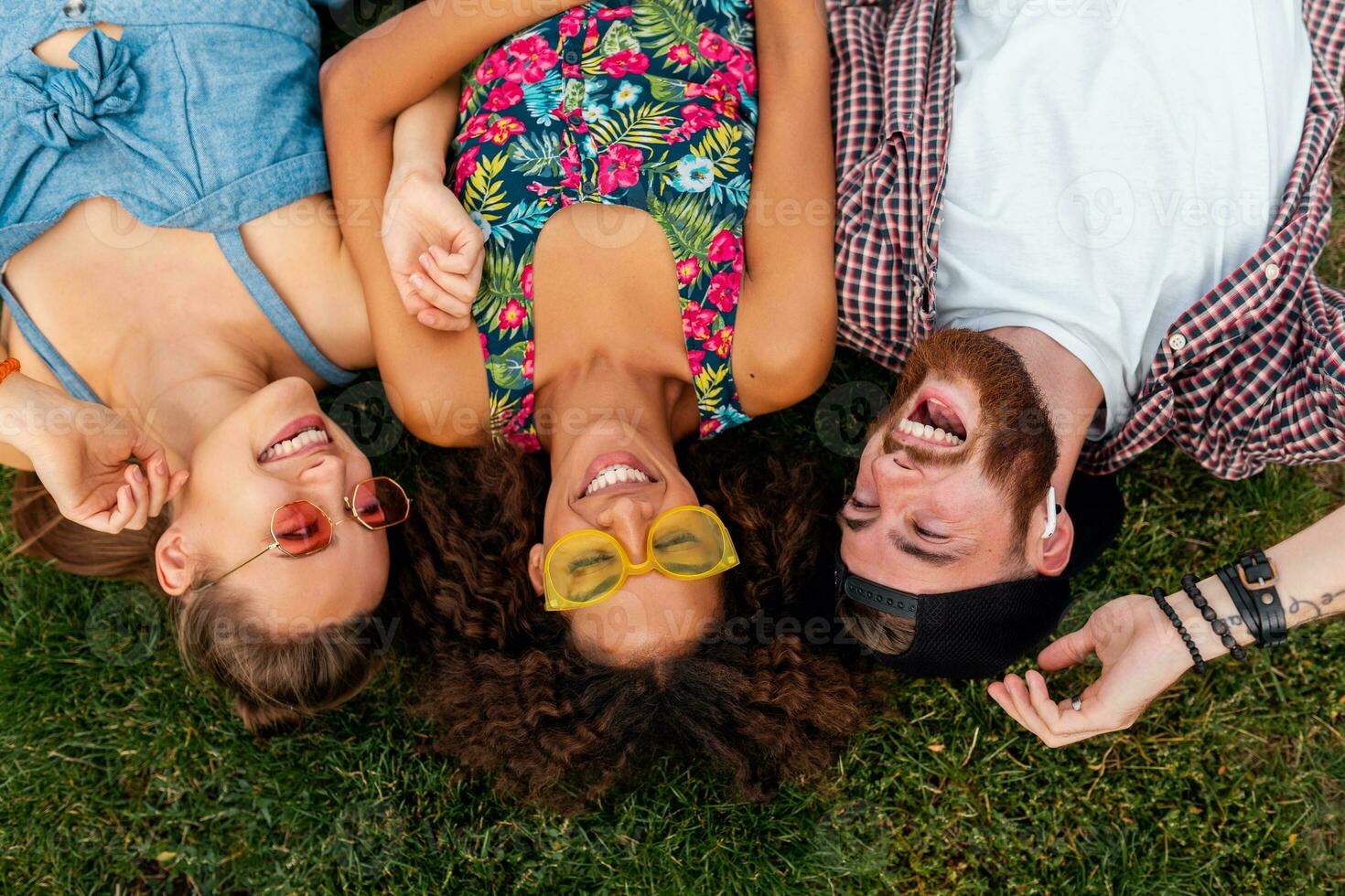 happy young company of talking smiling friends sitting park photo