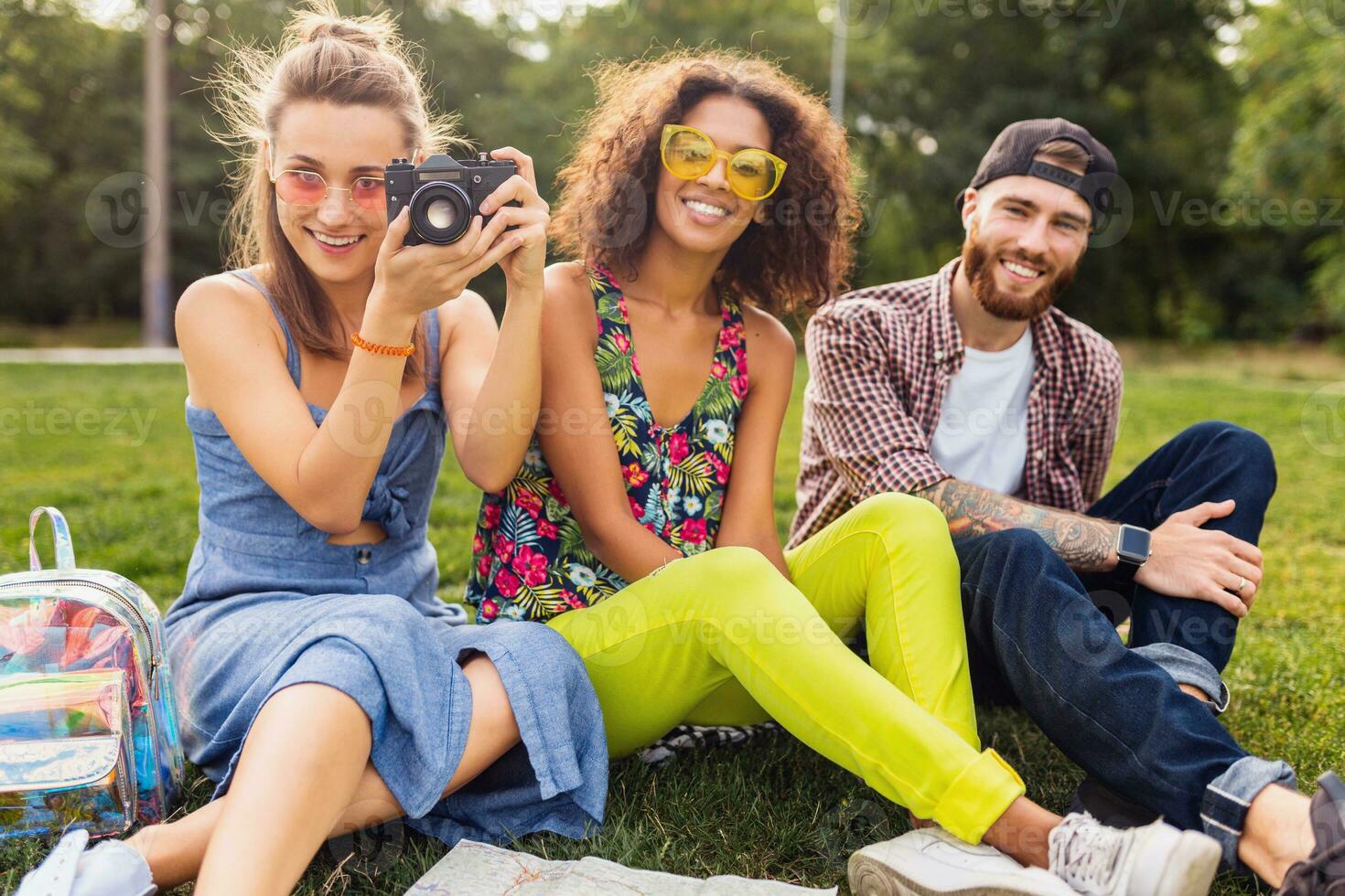 happy young company of friends sitting park photo