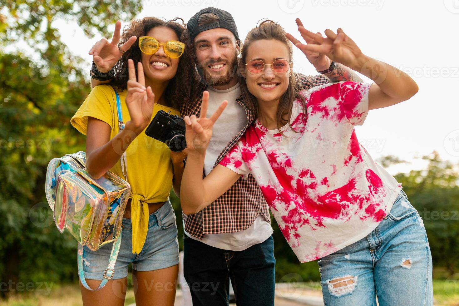 happy young company of emotional smiling friends walking in park photo