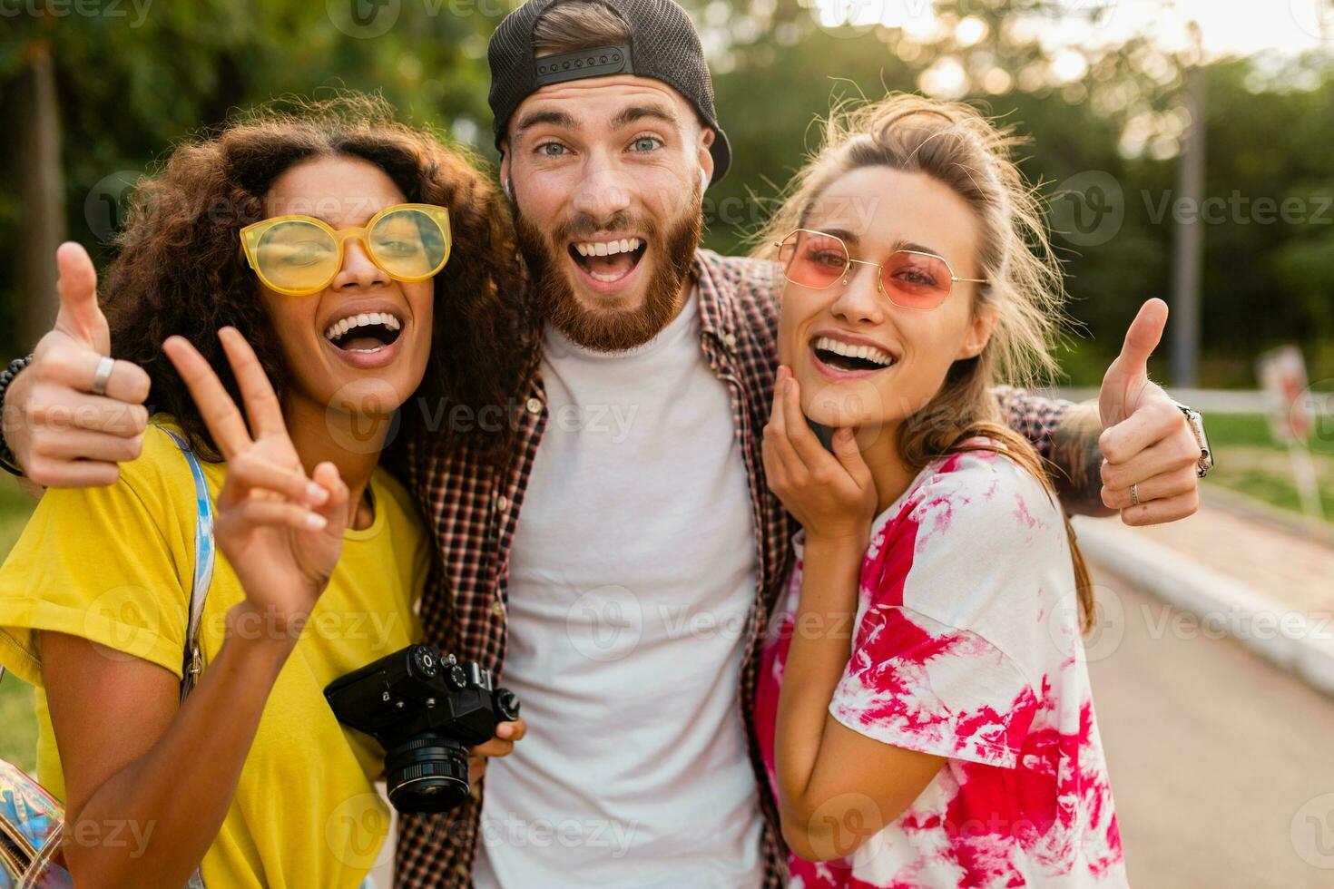 happy young company of emotional smiling friends walking in park photo