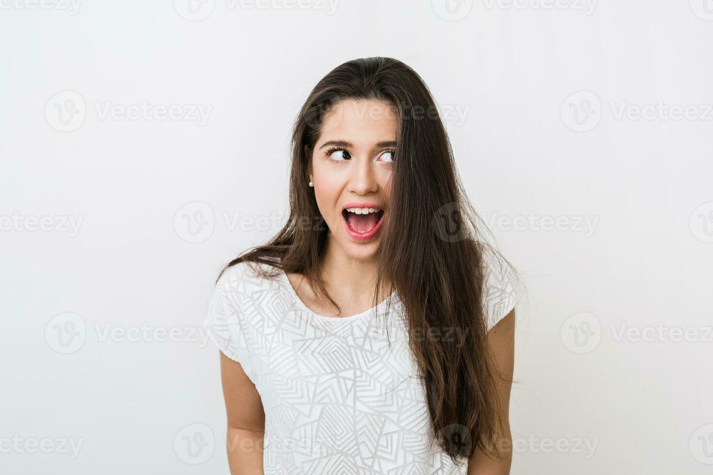 young pretty woman with funny face expression, open mouth, big eyes, looking aside, surprised mood, emotional photo