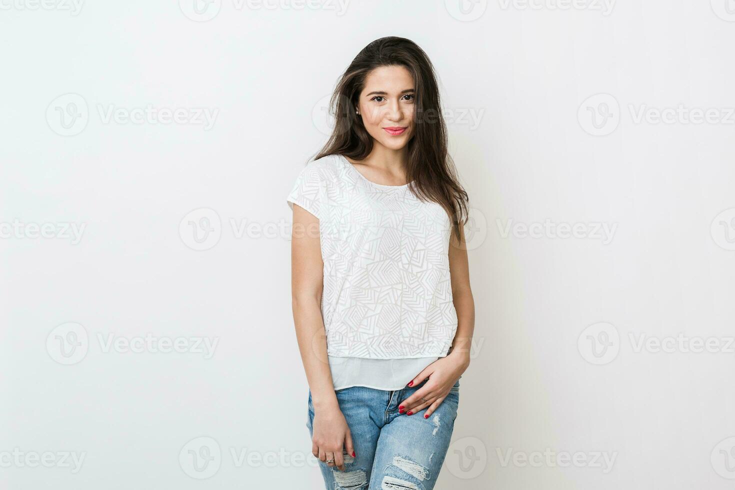 portrait of attractive young smiling woman in white blouse and jeans, long hair, fashion trend, simple apparel, natural look, casual style, isolated on studio background photo