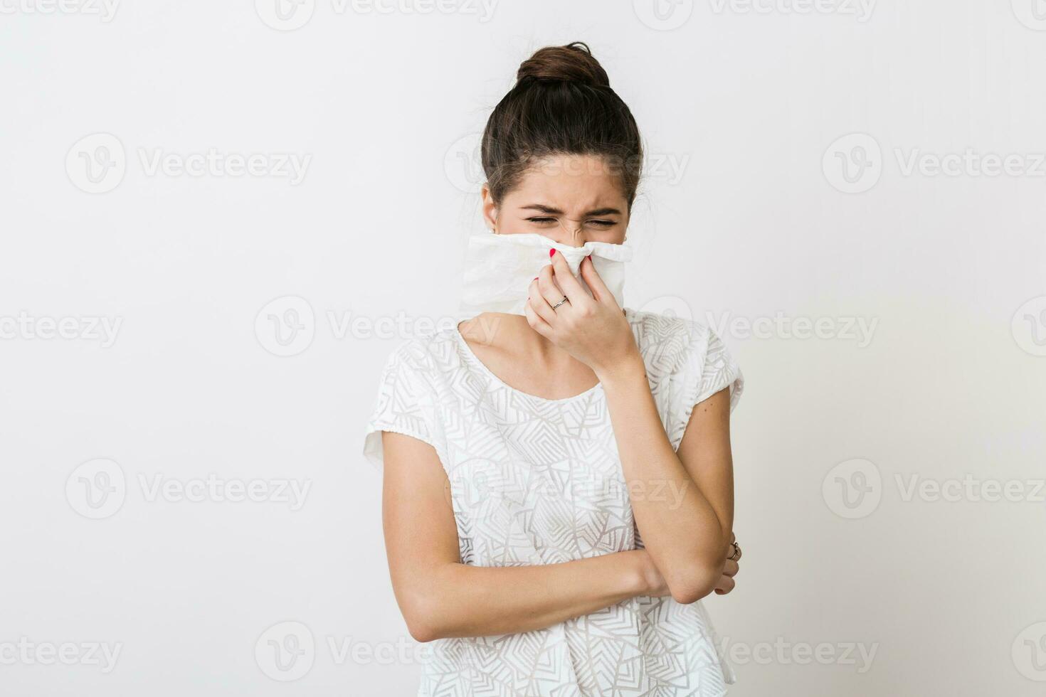 close-up portrait of pretty woman blowing her nose with napkin, catch a cold, feeling sick, isolated, white studio background, frowning photo