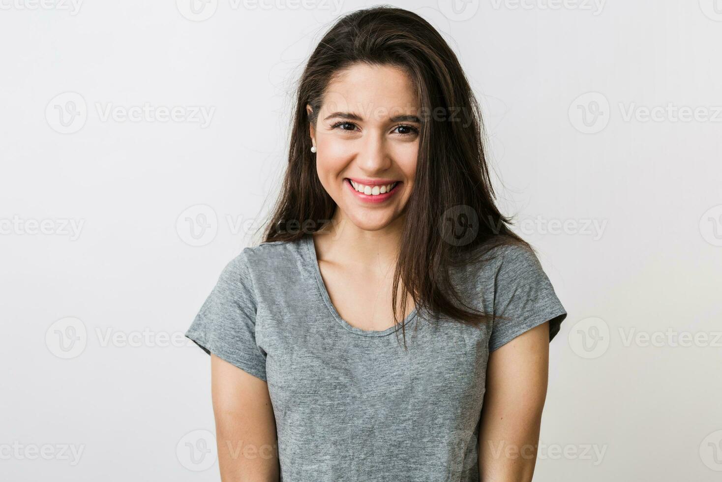 portrait of stylish young pretty woman smiling in grey t-shirt on white studio background, isolated, natural look, long brown hair, sincere smile photo