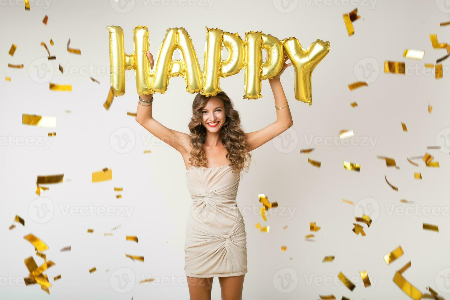 pretty woman celebrating party in golden confetti photo