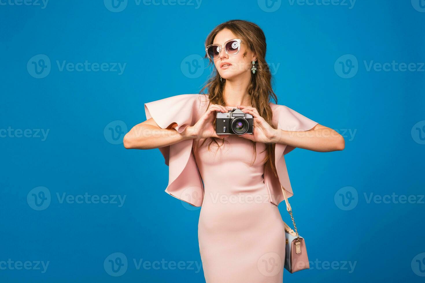 joven elegante sexy mujer en rosado lujo vestir tomando imágenes en Clásico cámara foto