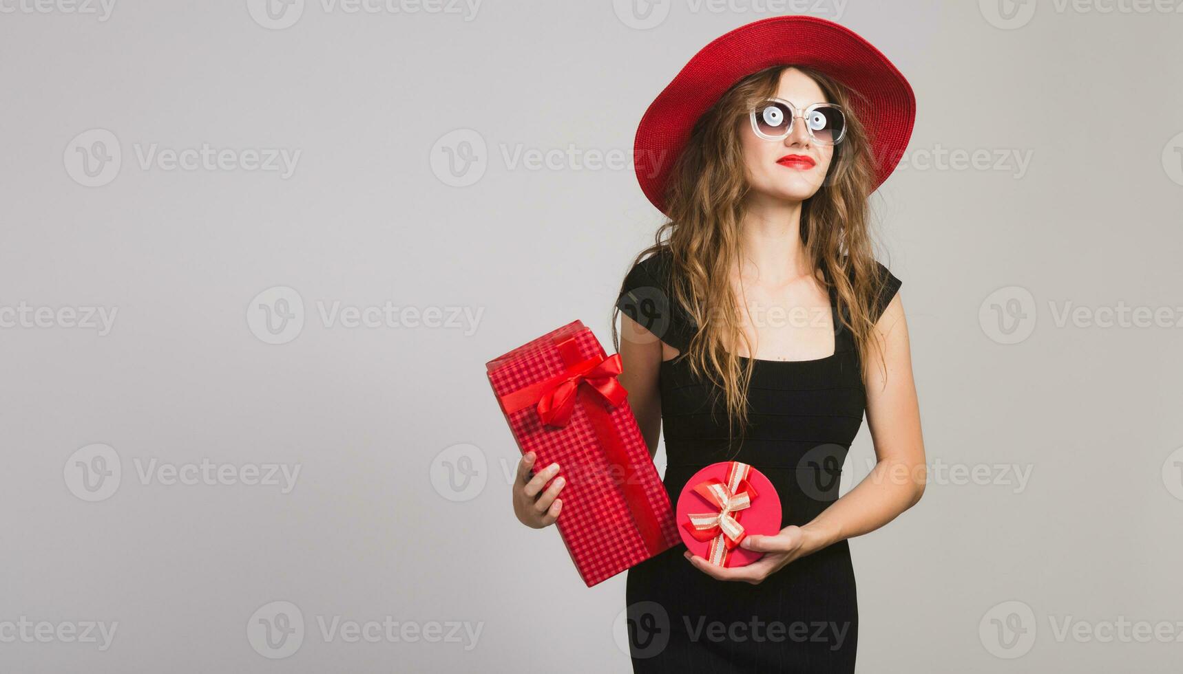 young beautiful woman holding presents, black dress, red hat photo