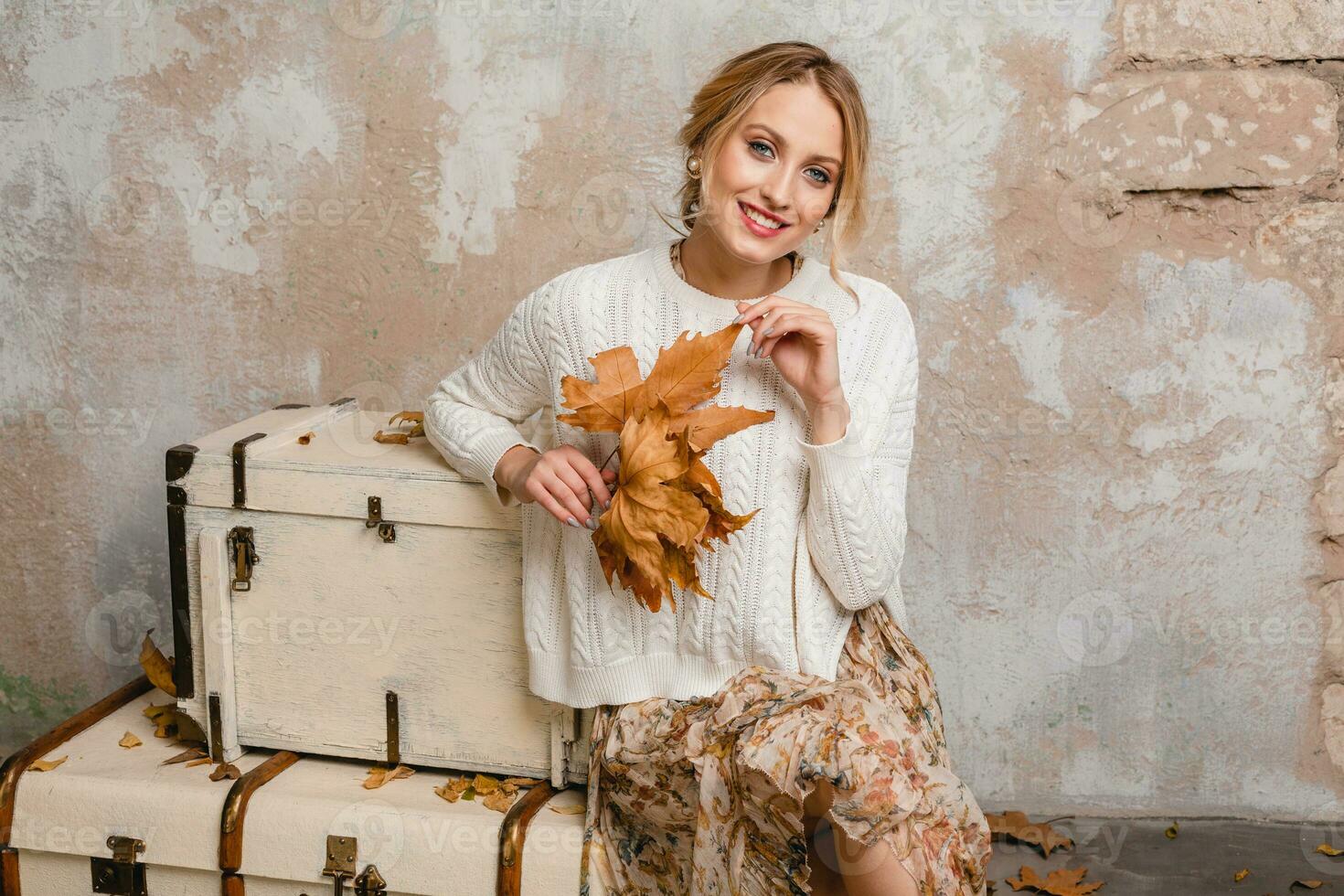 portrait of attractive smiling stylish blonde woman in white knitted sweater photo