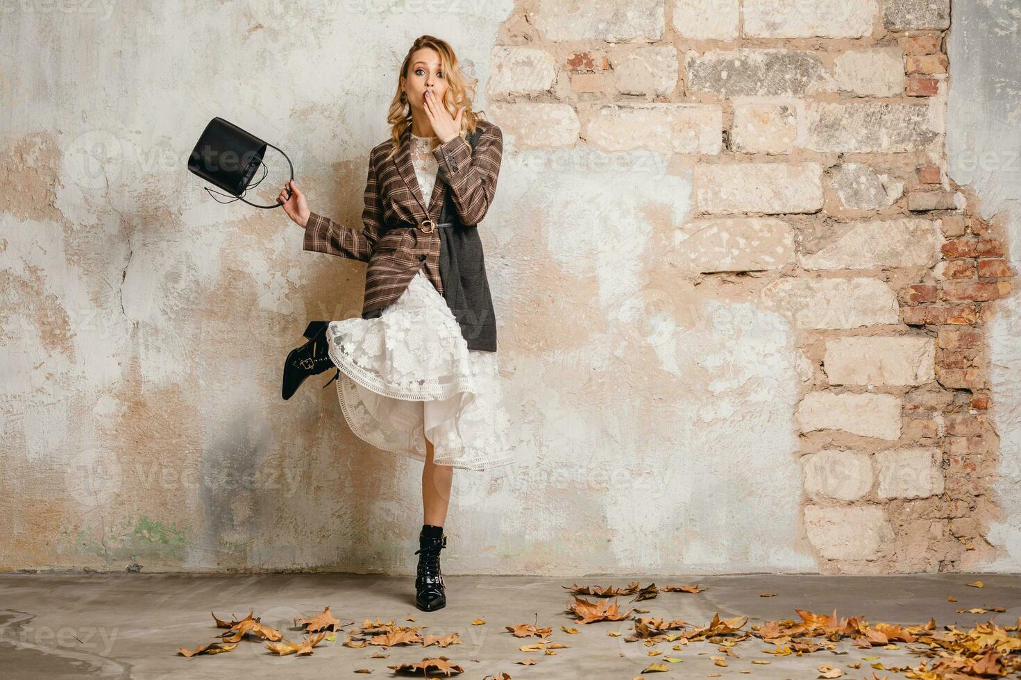 atractivo elegante rubia mujer en a cuadros chaqueta Saco caminando, otoño Moda tendencia foto