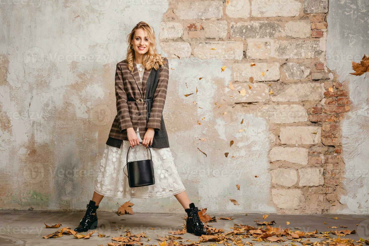 attractive stylish blonde woman in checkered jacket coat walking, autumn fashion trend photo
