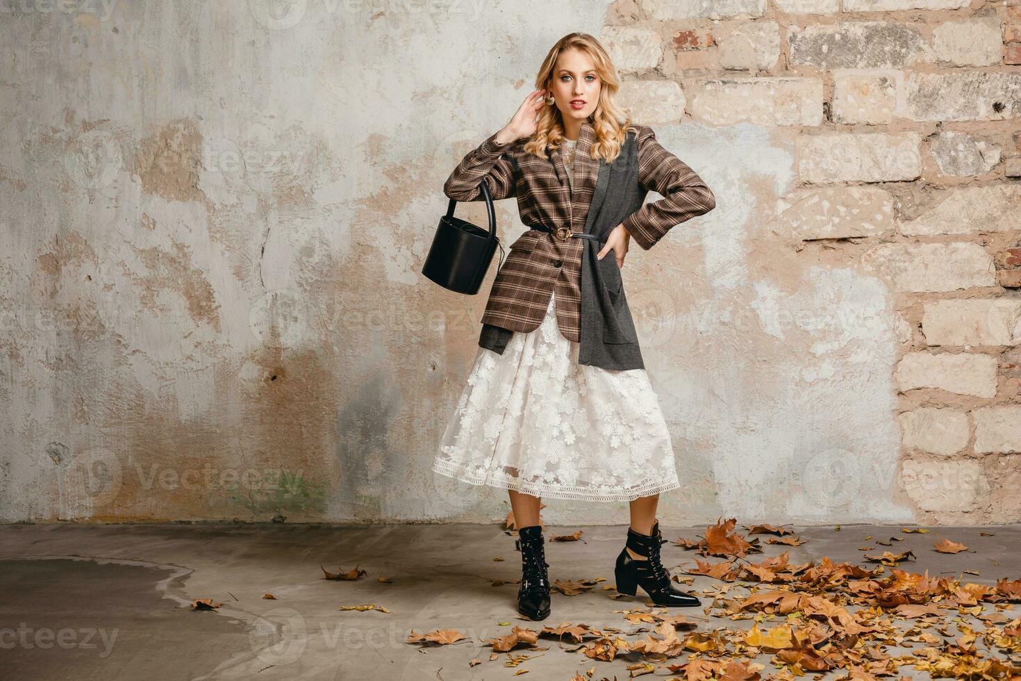 attractive stylish blonde woman in checkered jacket coat walking, autumn fashion trend photo