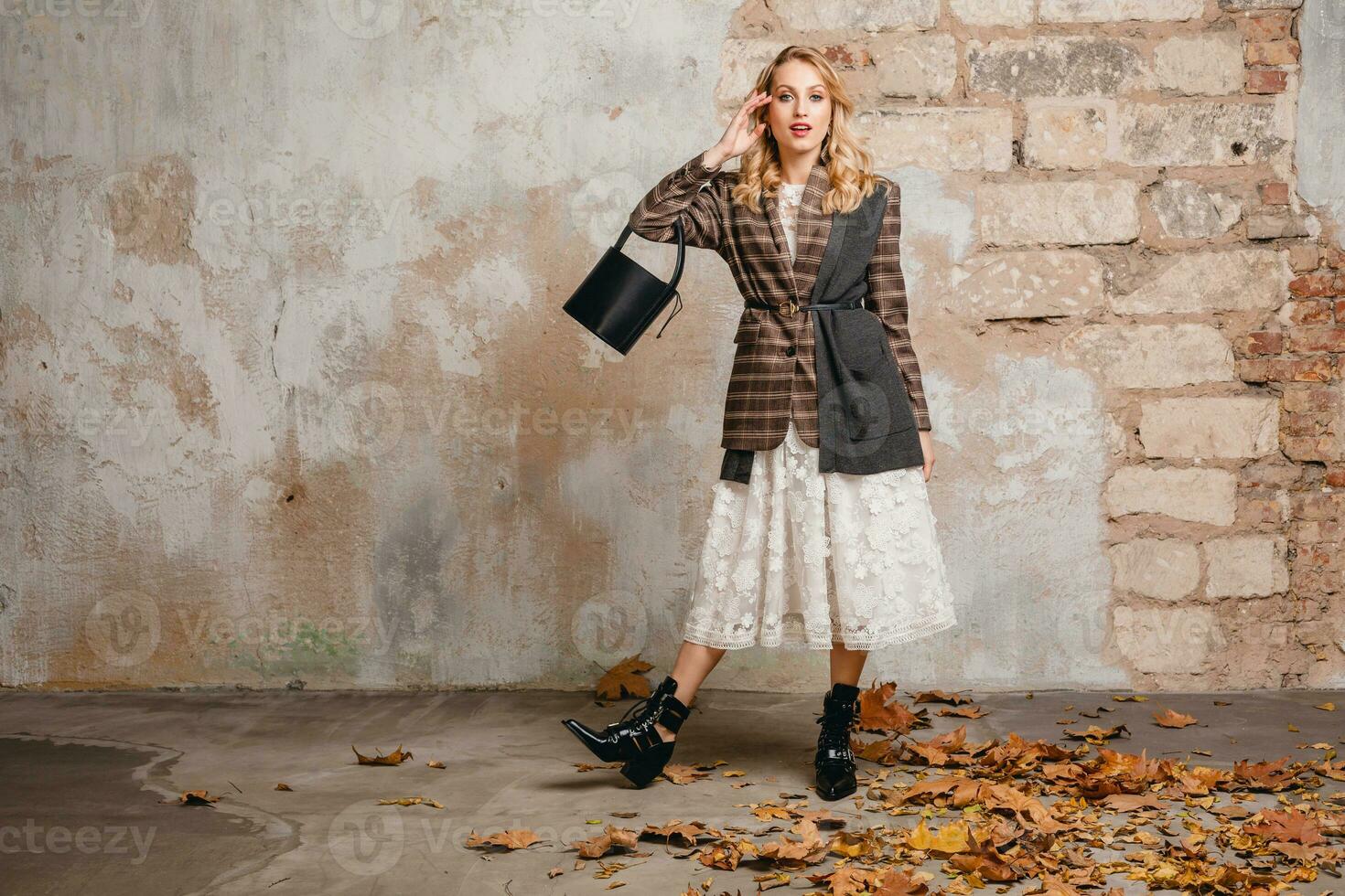 attractive stylish blonde woman in checkered jacket coat walking, autumn fashion trend photo