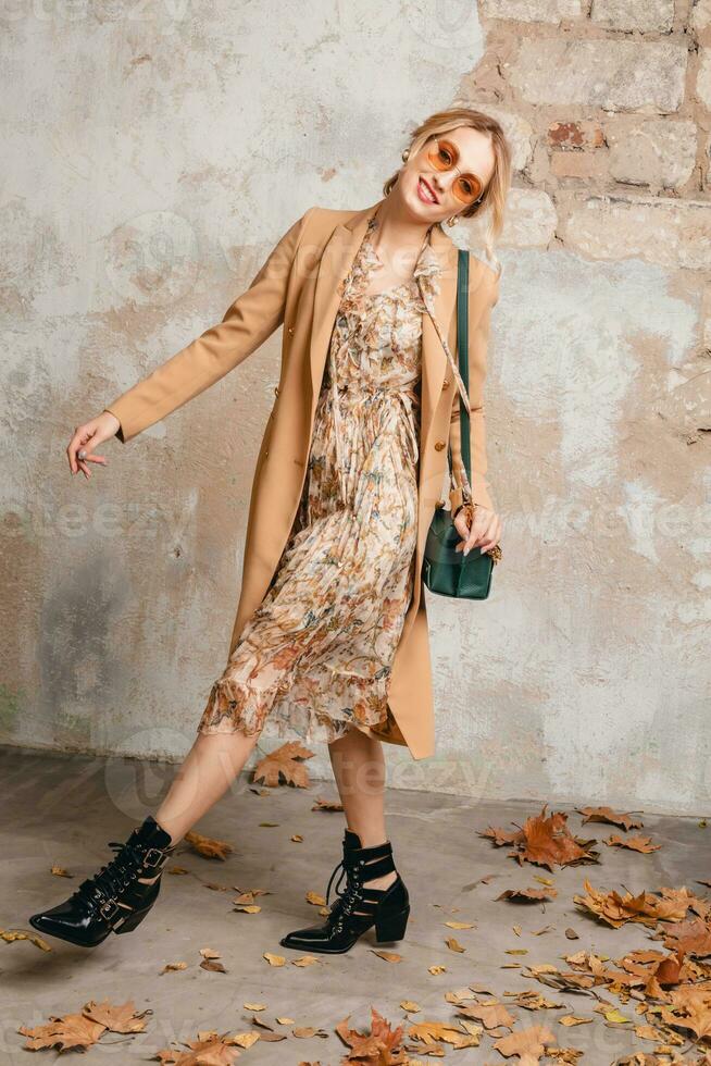 attractive stylish blonde woman in beige coat, spring autumn fashion trend photo