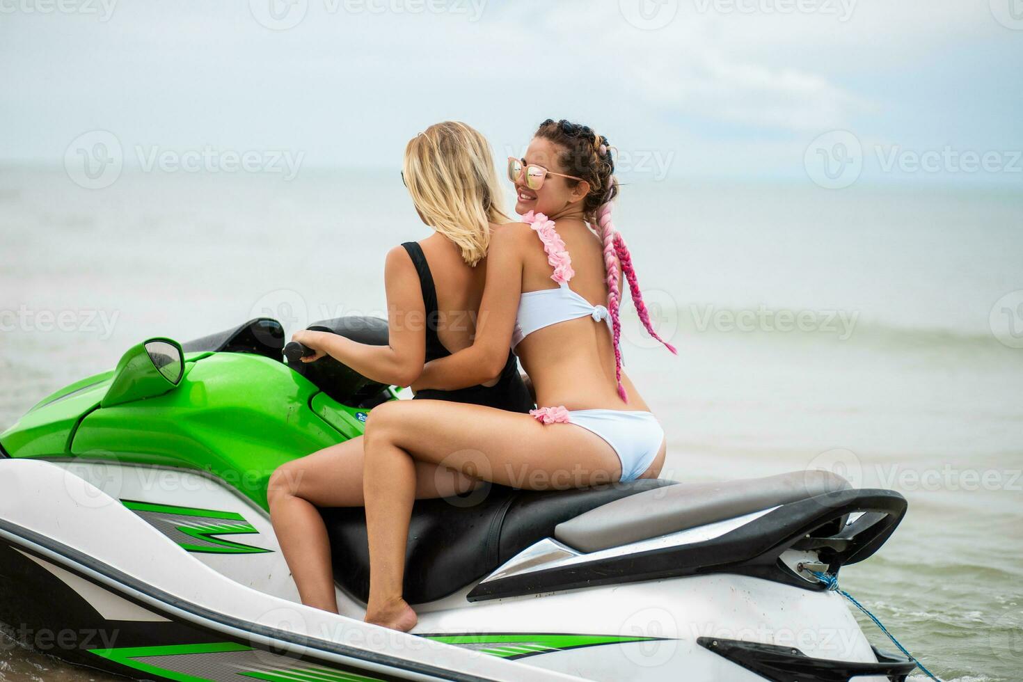 two sexy women in bikini on water scooter in sea summer style photo