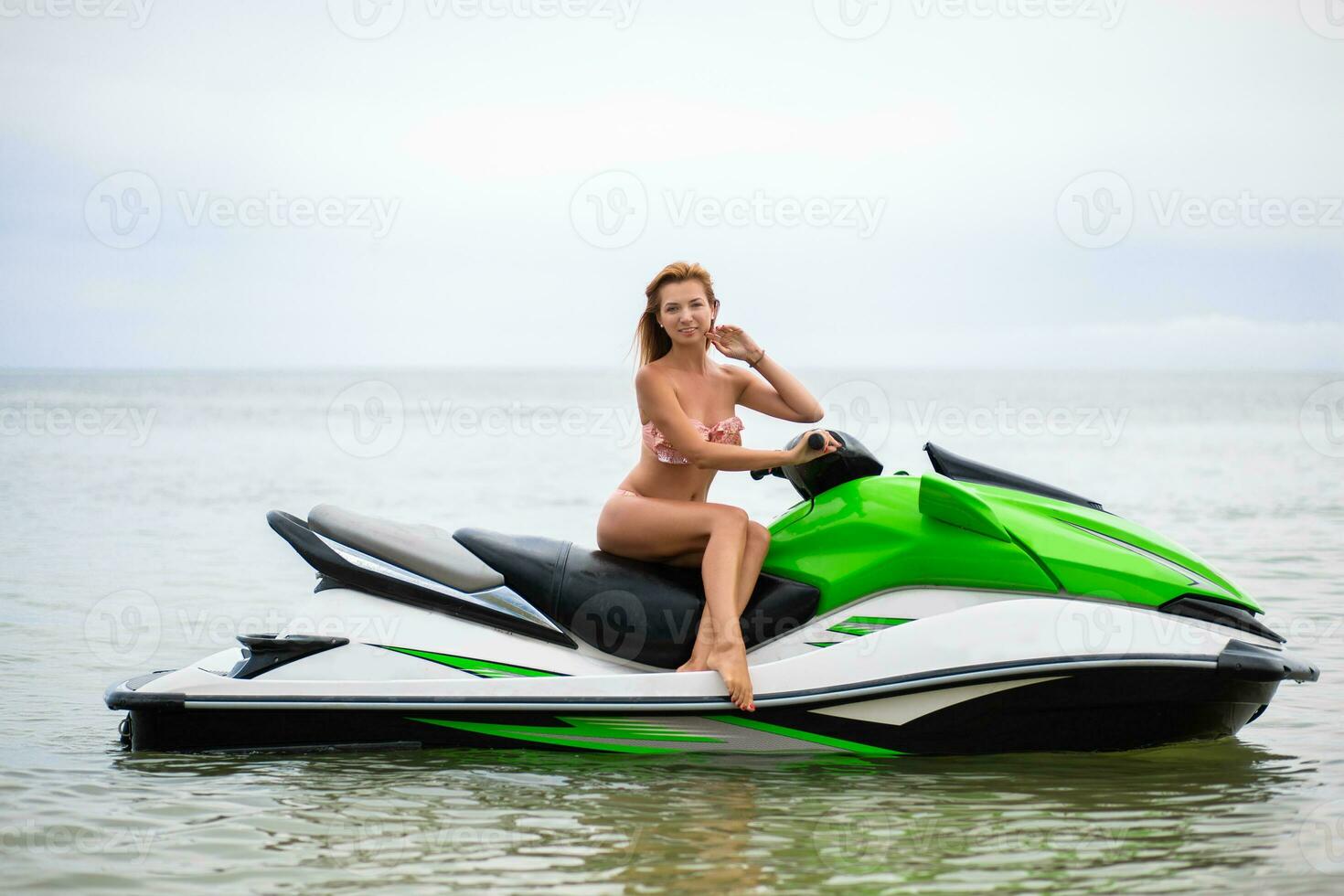 sexy woman in bikini on water scooter in sea summer style photo