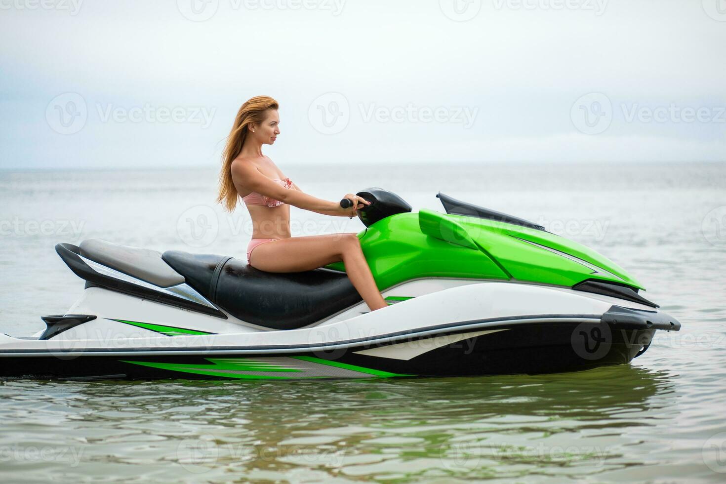 sexy woman in bikini on water scooter in sea summer style photo
