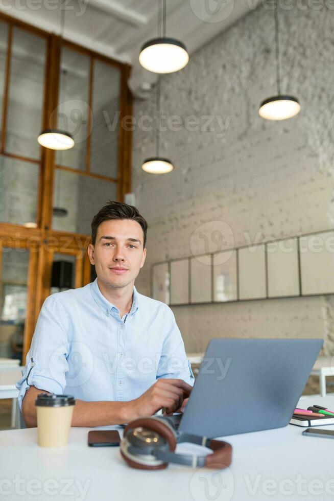 contento joven confidente hombre trabajando en ordenador portátil foto