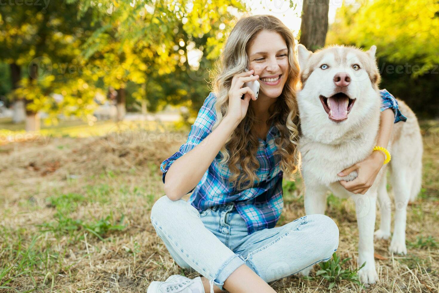 woman with dog talking on phone photo