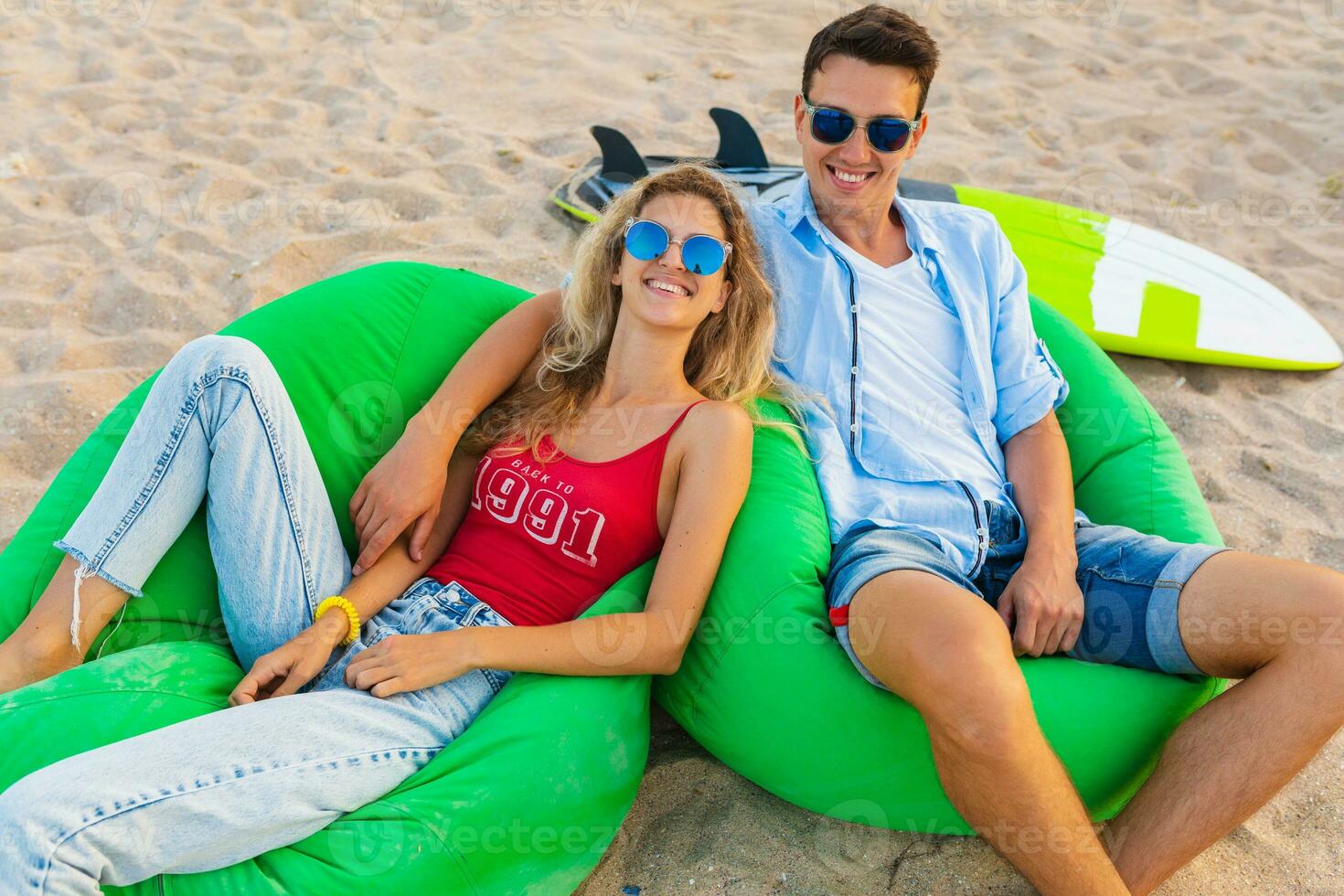 young smiling couple having fun on beach relaxing photo