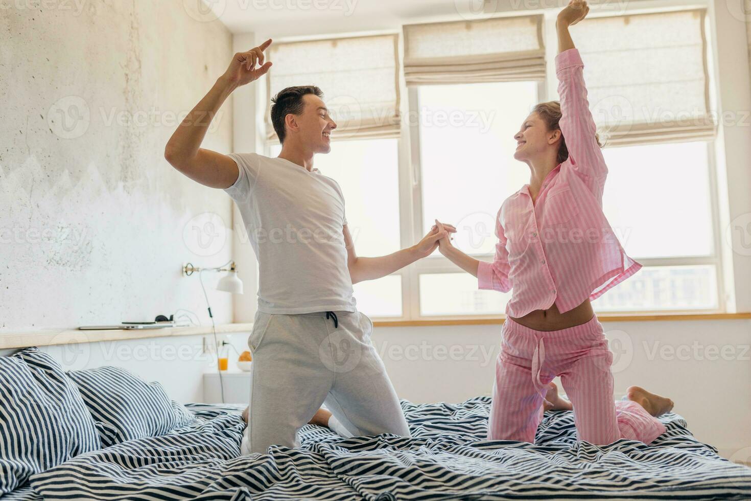 young couple having fun on bed in morning photo