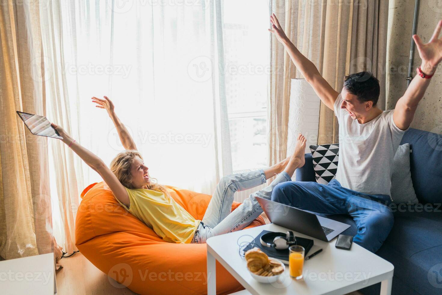 joven hombre y mujer en amor sentado a hogar trabajando en línea foto