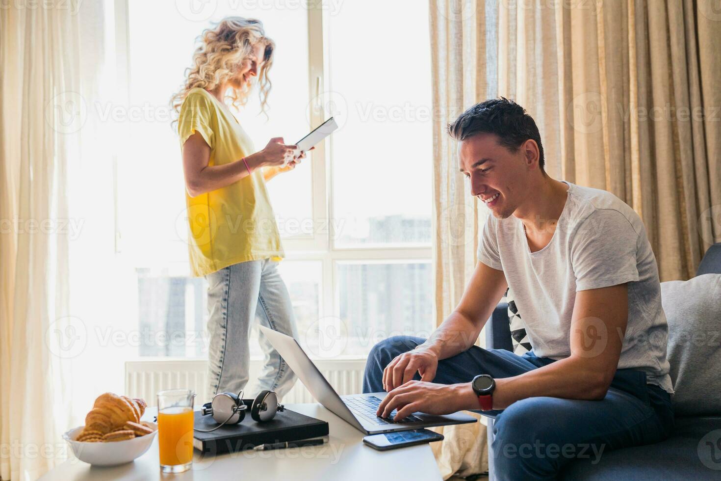 young man and woman in love sitting at home working online photo