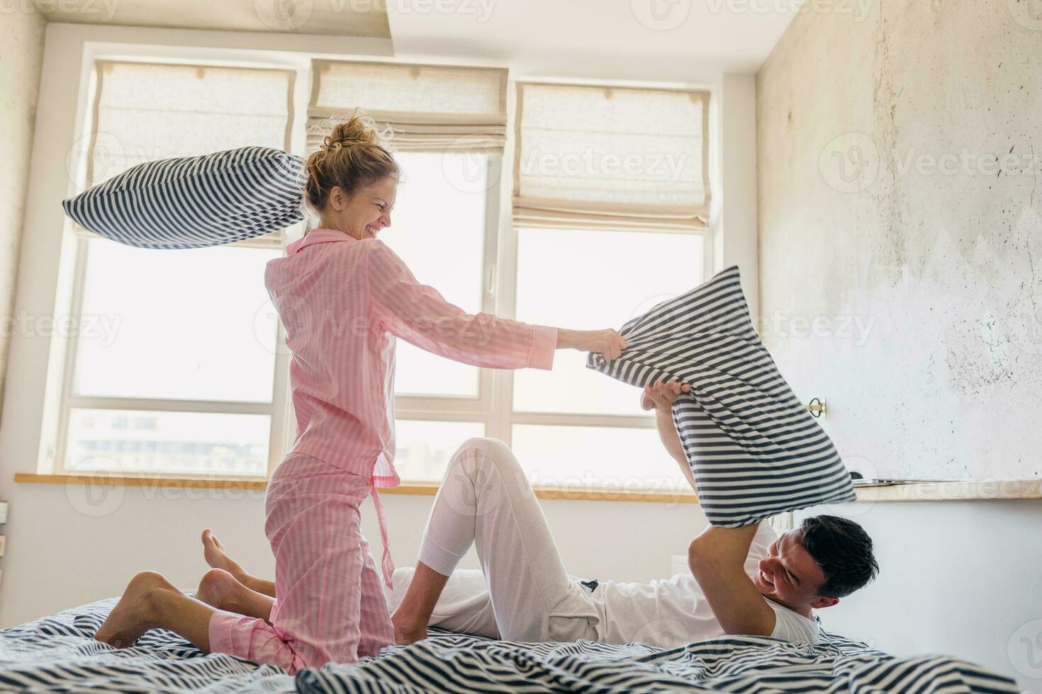 funny young couple having fun on bed in morning photo