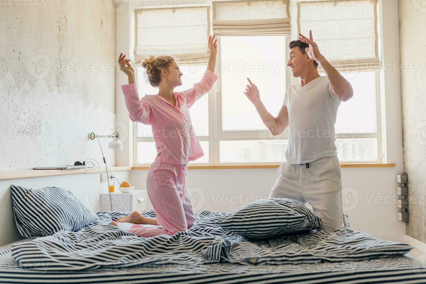 funny young couple having fun on bed in morning photo