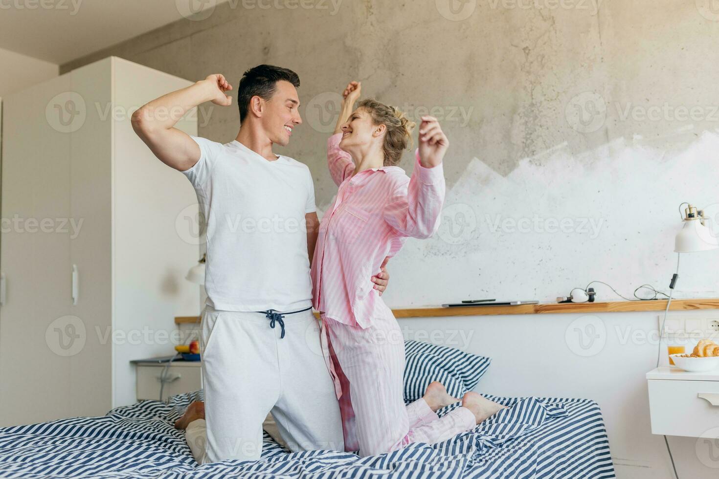 funny young couple having fun on bed in morning photo