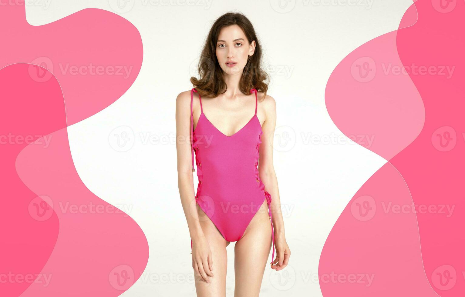 attractive woman with slim skinny body posing in pink printed swimsuit isolated on white studio background, summer beachwear fashion trend photo