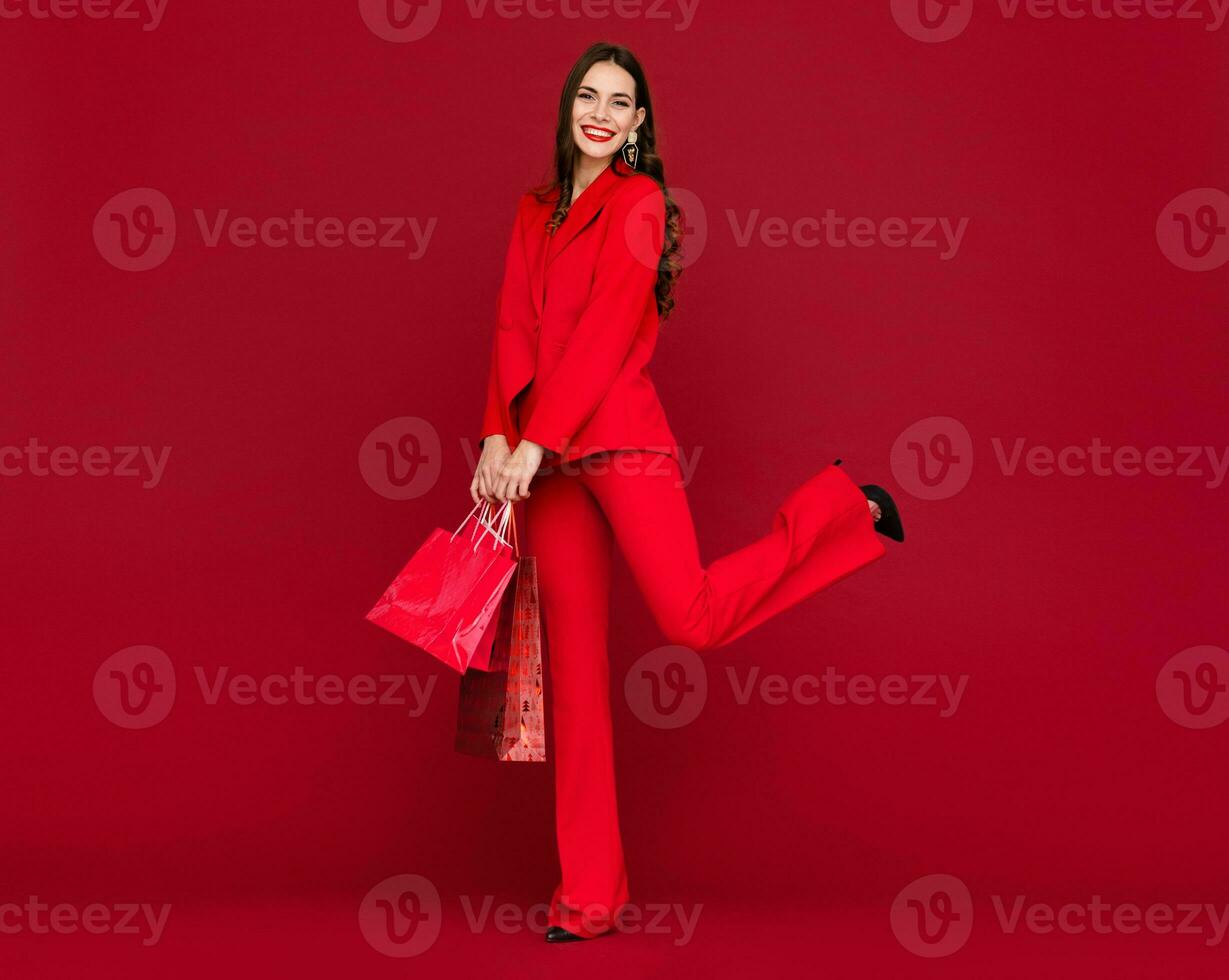 atractivo mujer en rojo con compras pantalones rebaja en rojo antecedentes foto