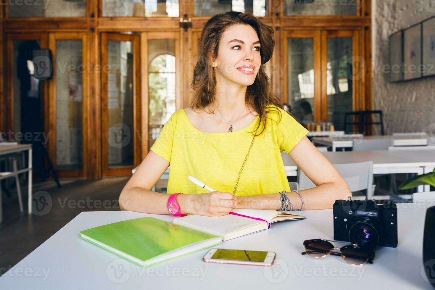 portrait of young pretty woman sitting at table, student learning photo