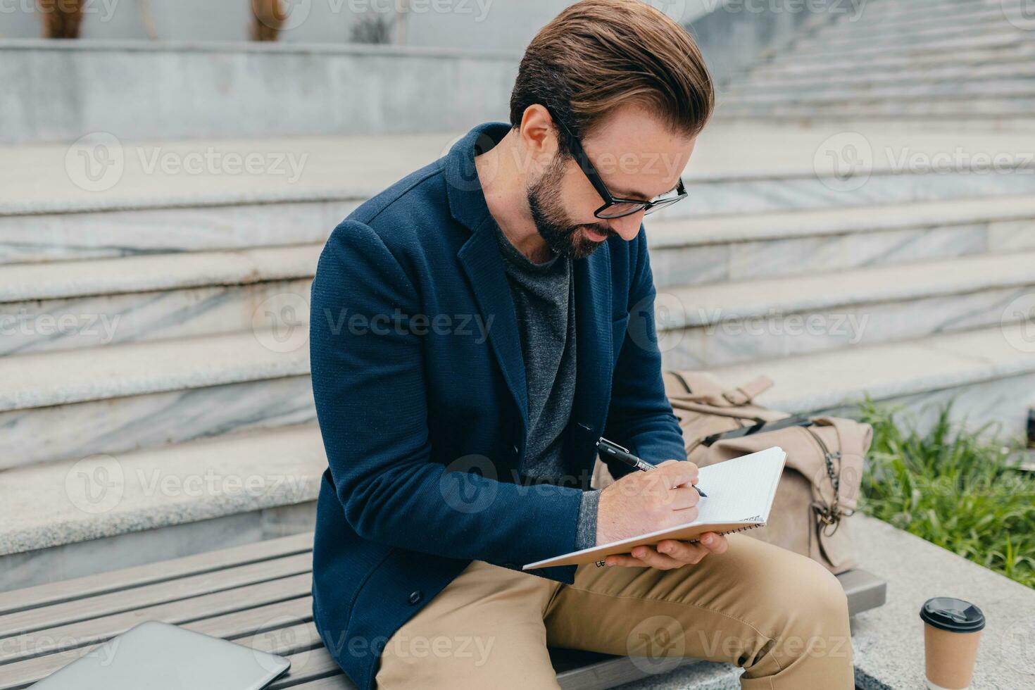 handsome busy bearded man working in park photo