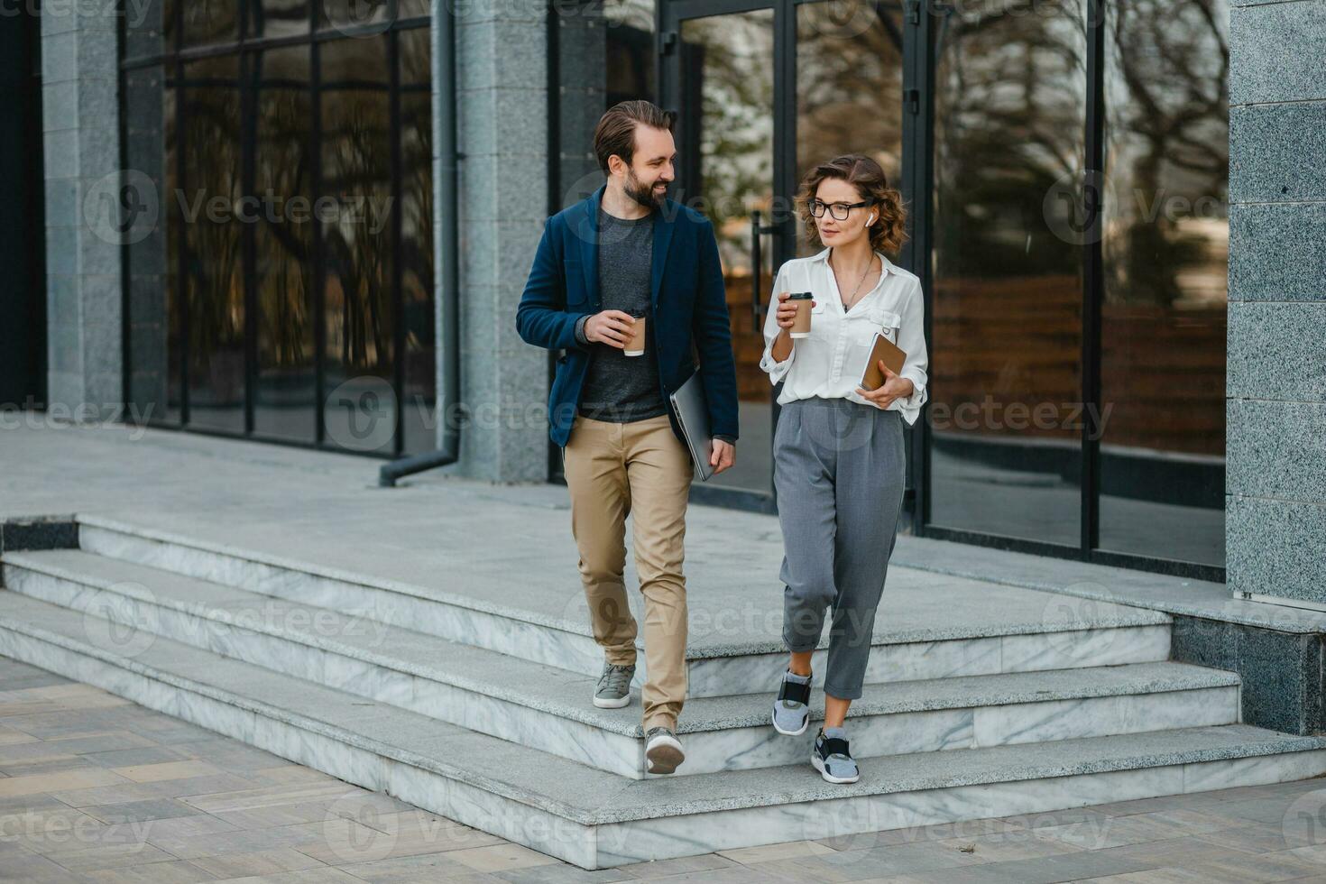 man and woman business partners working together in park photo