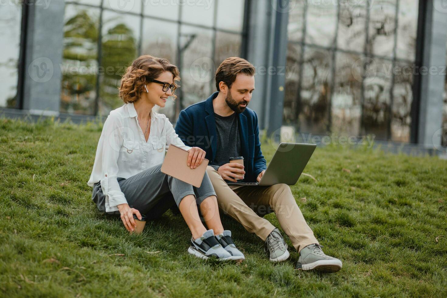 man and woman business partners working together in park photo