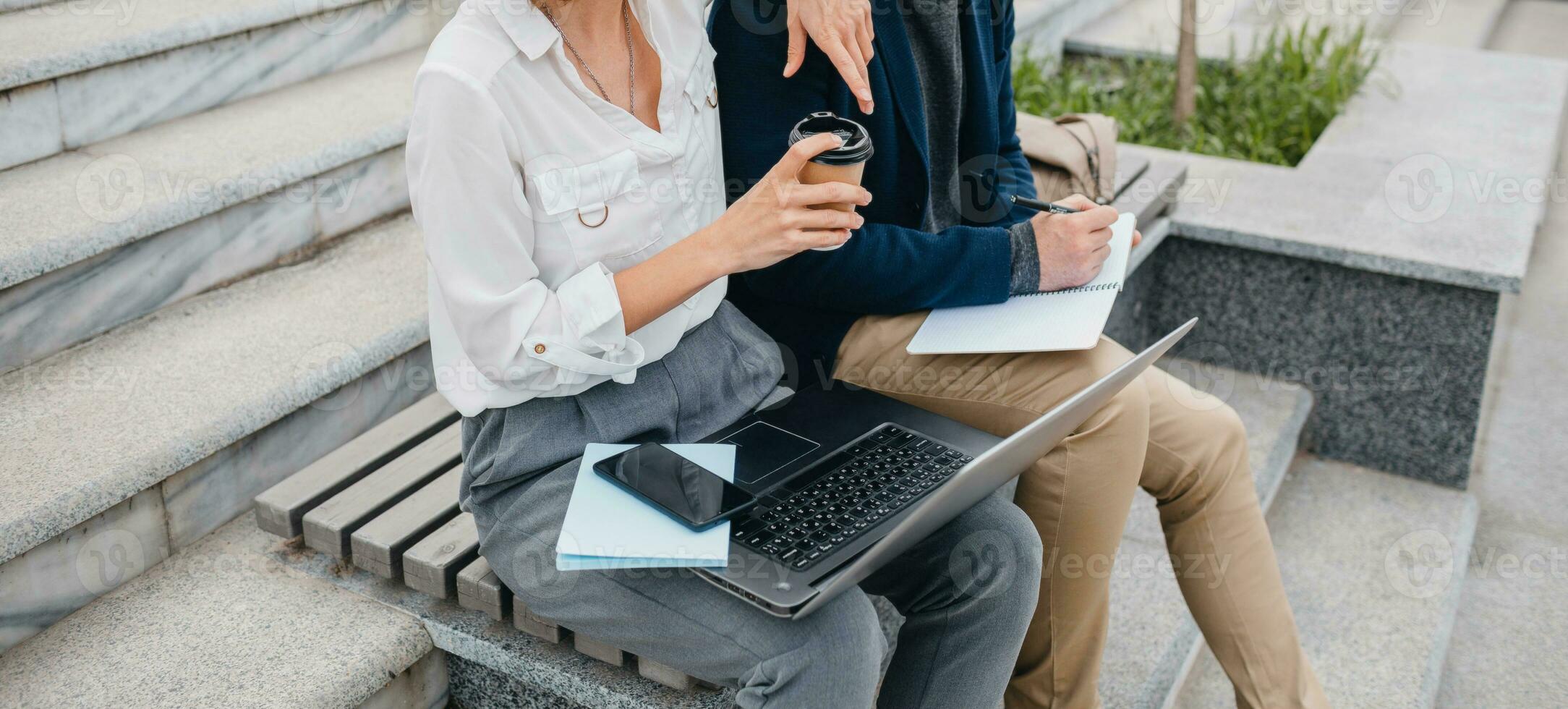 man and woman working together in park photo