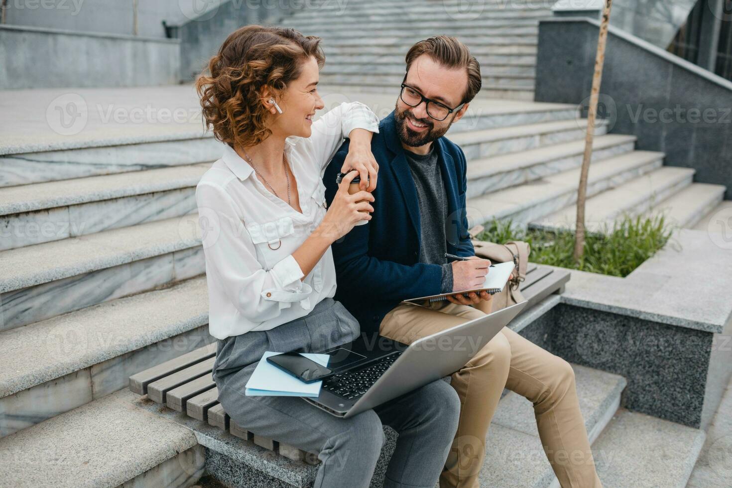 man and woman working together in park photo