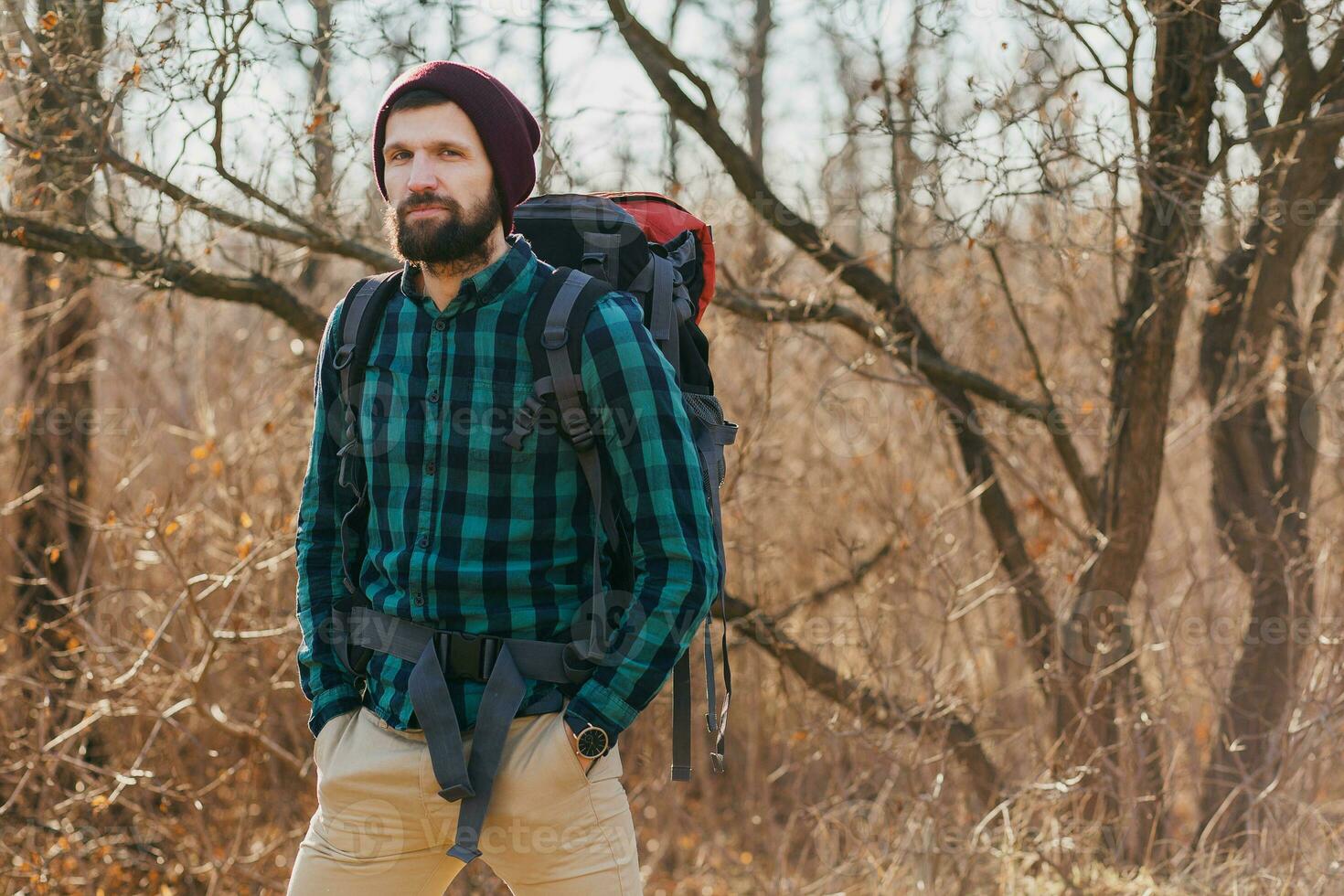 young hipster man traveling with backpack in spring autumn forest photo