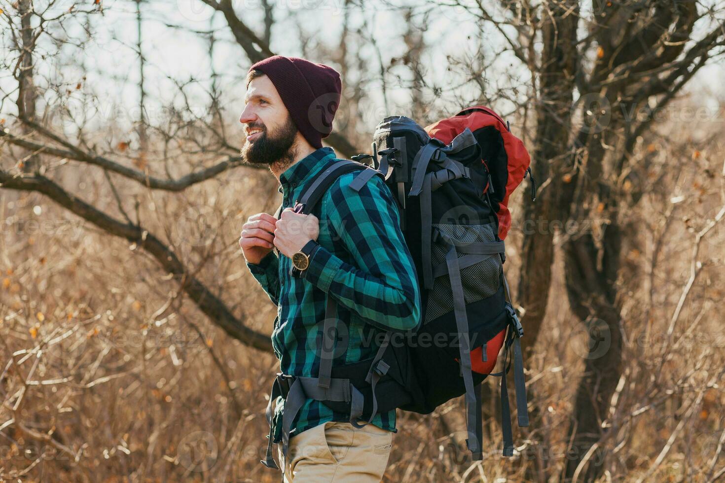 young hipster man traveling with backpack in spring autumn forest photo