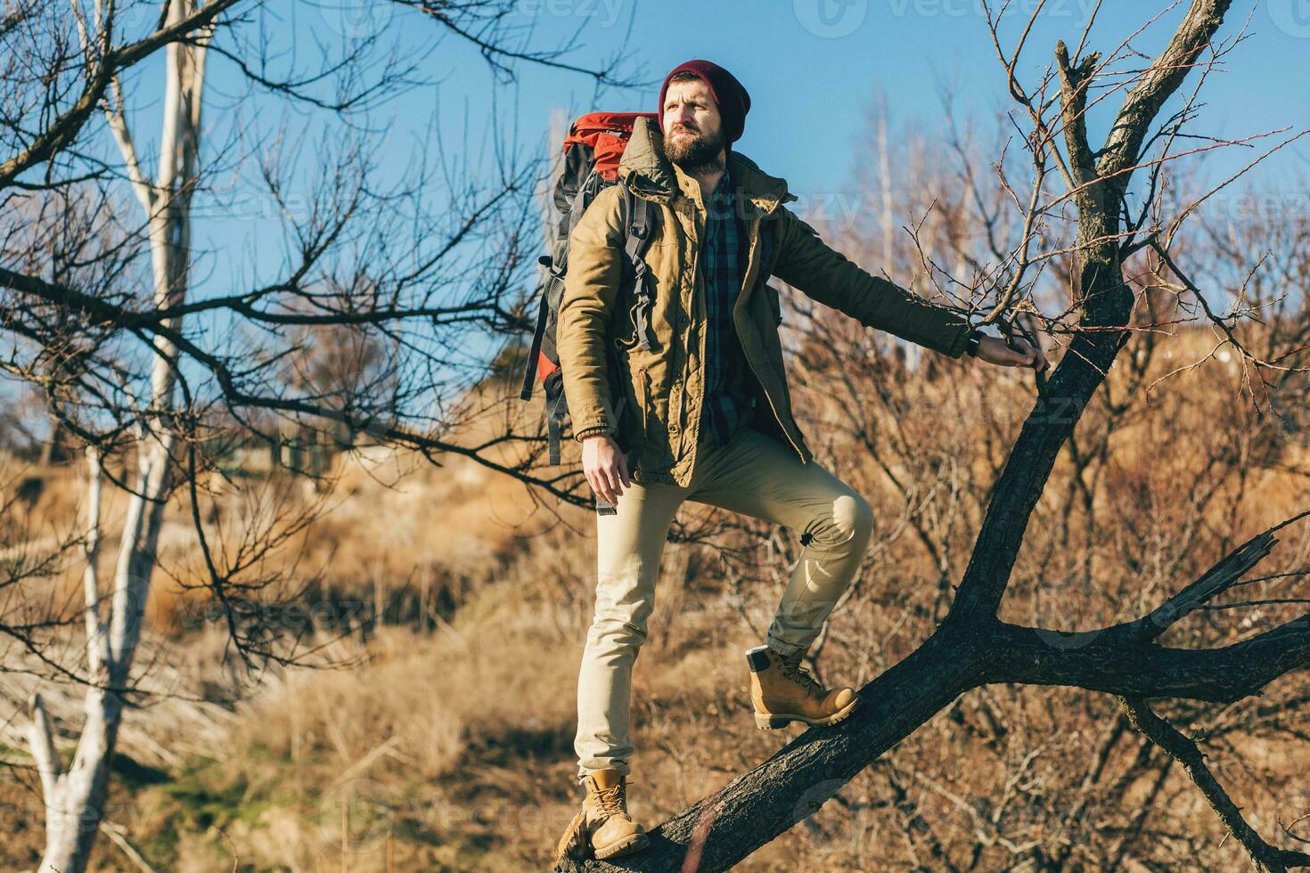 young hipster man traveling with backpack in cold season photo