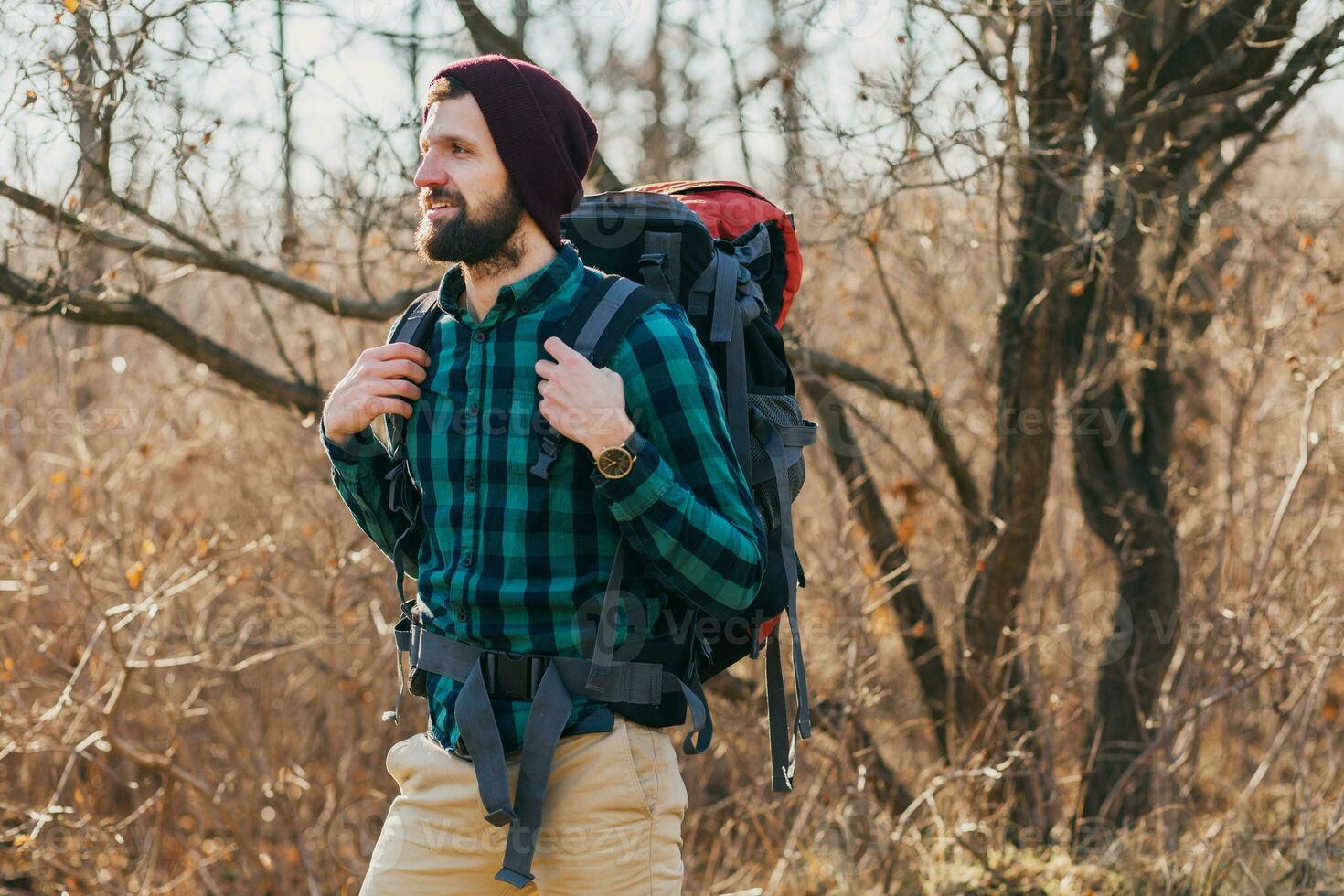young hipster man traveling with backpack in spring autumn forest photo