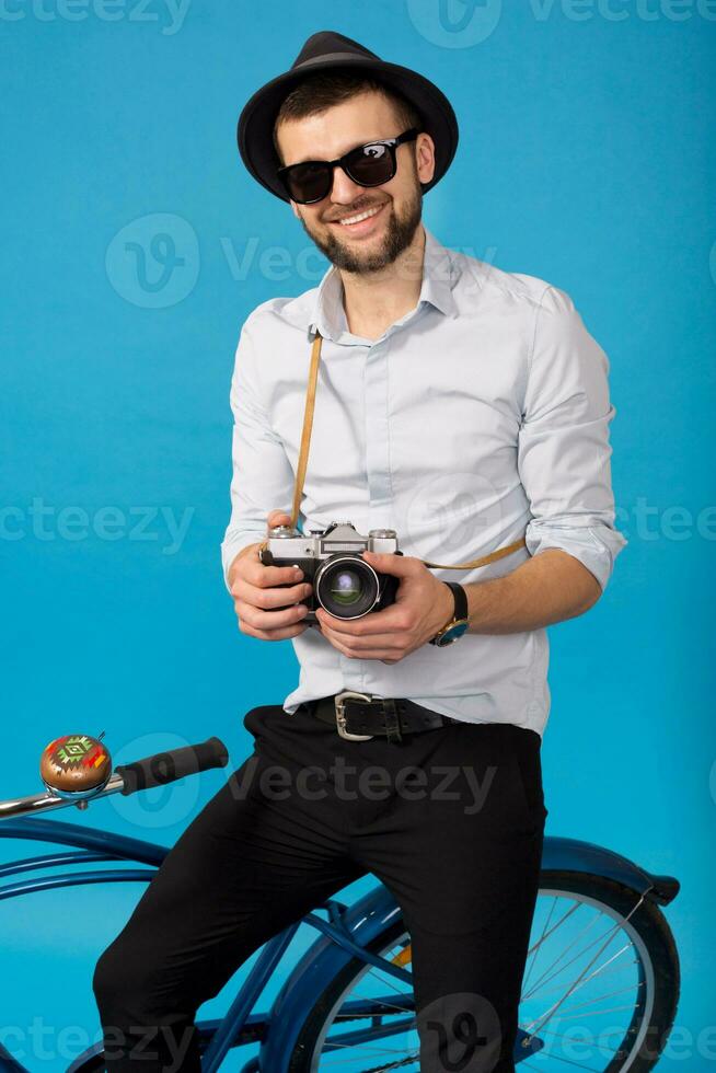 joven hermoso sonriente contento hombre de viaje en hipster bicicleta foto