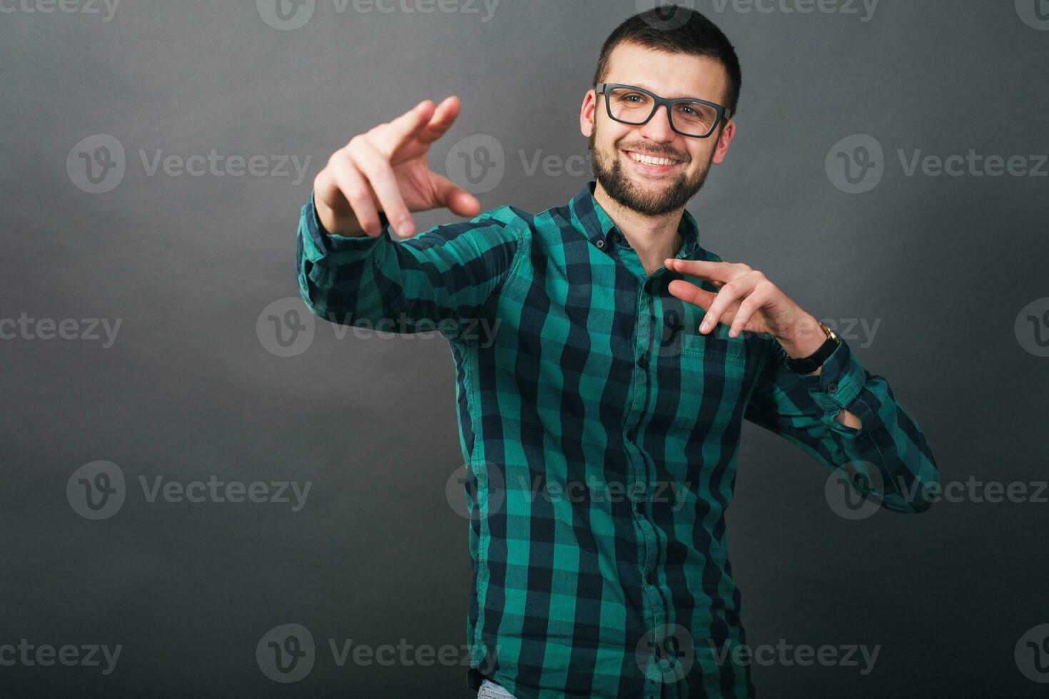 young handsome hipster bearded man on grey background, green checkered shirt photo