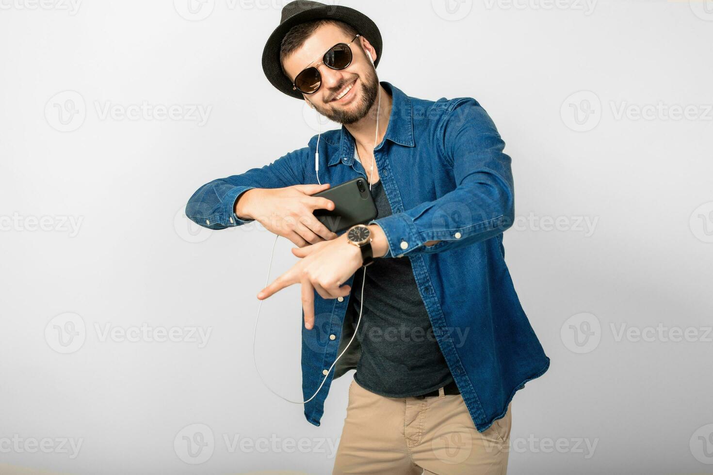 young handsome happy smiling man listening to music in earphones photo