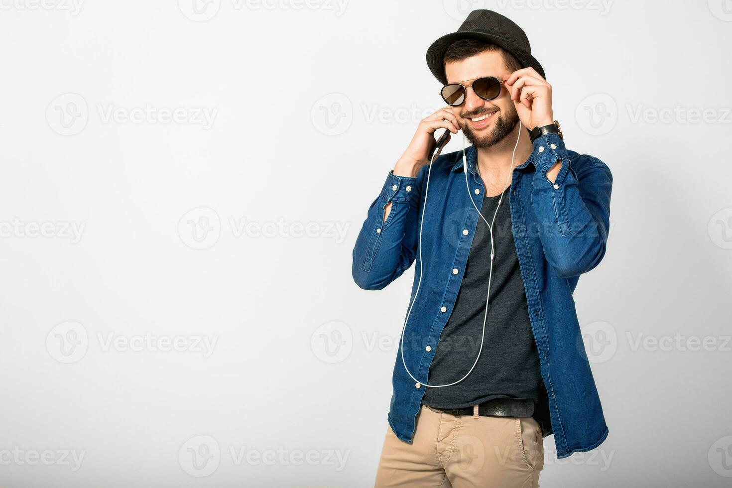 young handsome happy smiling man listening to music in earphones photo