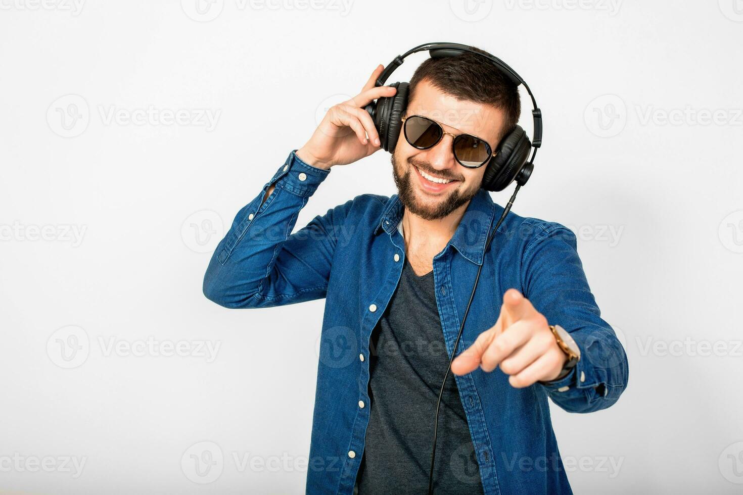 joven hermoso contento sonriente hombre bailando y escuchando a música en auriculares foto